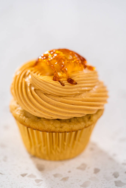 Freshly baked dulce de leche cupcakes on a kitchen counter. - Foto, afbeelding