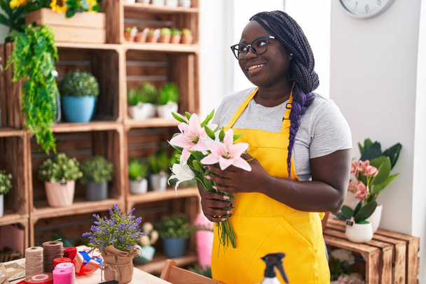 Afroamerykanka kobieta kwiaciarnia gospodarstwa bukiet kwiatów w kwiaciarnia - Zdjęcie, obraz