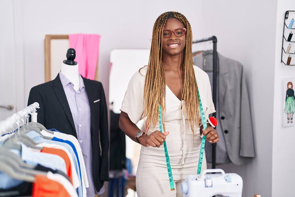 Femme afro-américaine tailleur souriant confiance debout au magasin de tailleur - Photo, image