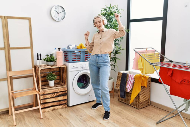 Young caucasian woman smiling confident dancing at laundry room - Foto, Imagem