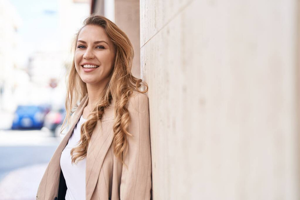 Nuori blondi nainen hymyilee luottavainen seisoo puistossa - Valokuva, kuva
