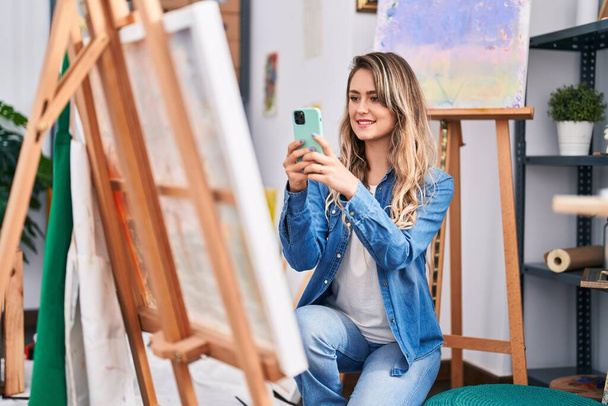 Νεαρή γυναίκα καλλιτέχνης κάνει φωτογραφία για να ζωγραφίσει στο στούντιο τέχνης - Φωτογραφία, εικόνα
