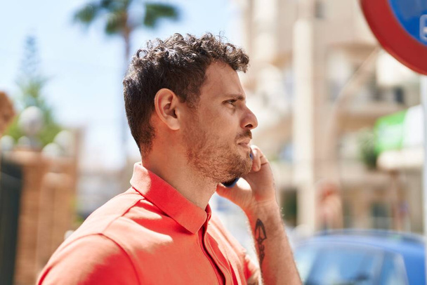 Young hispanic man talking on the smartphone at street - Foto, Bild