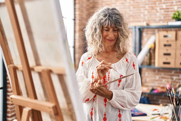 Kobieta w średnim wieku artystka uśmiecha się pewnie rysunek w studio sztuki - Zdjęcie, obraz