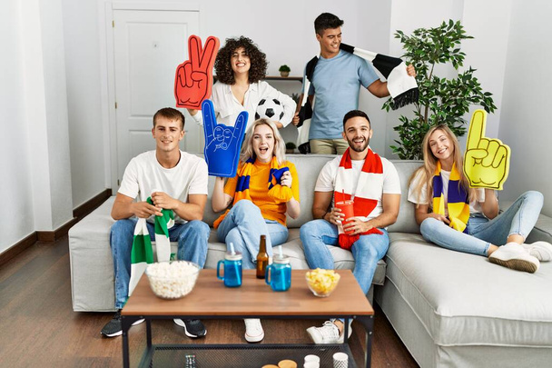 Group of young friends watching and supporting soccer match at home. - Photo, image