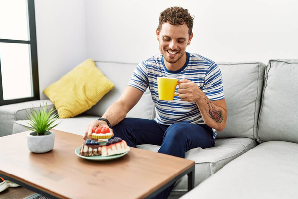Young hispanic man smiling confident having breakfast at home - Fotografie, Obrázek
