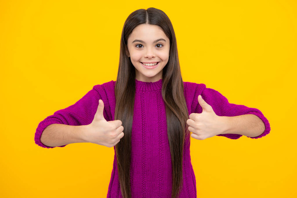 Children gesture. Happy teenager kid girl in casual clothes showing thumbs up - 写真・画像