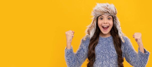 teen girl in knitwear on yellow background. portrait of child wearing warm clothes. Banner of child girl in winter hat, studio poster header with copy space - Photo, Image
