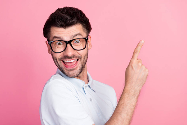 Closeup photo of young attractive handsome nice guy wear white polo t-shirt excited finger pointing empty space new proposition isolated on pink color background. - Fotó, kép