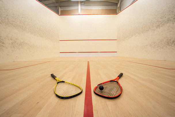 Leere Squash Court Ultra-Weitwinkel-Ansicht. Schläger und Ball auf dem Boden, keine Menschen. - Foto, Bild