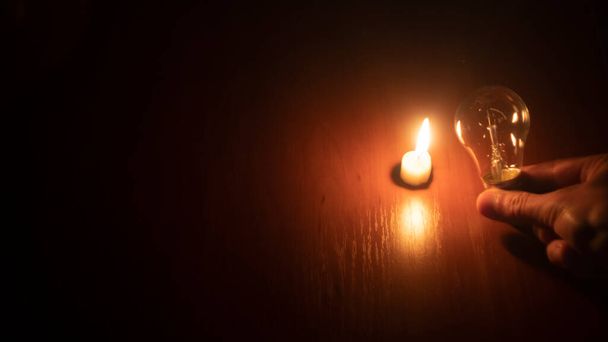lampadina e candela su sfondo nero - Foto, immagini