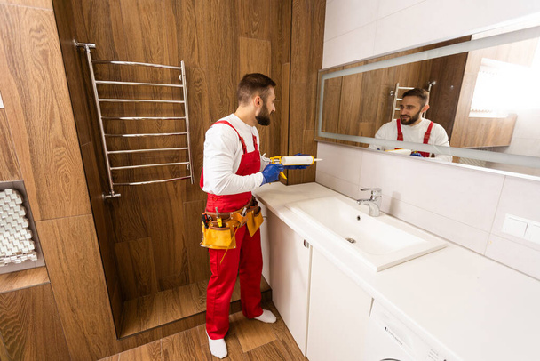 Professional plumber with plunger and instruments near sink - Φωτογραφία, εικόνα
