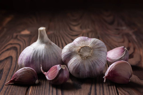 Garlic bulb on wooden background. Close up. - Foto, afbeelding