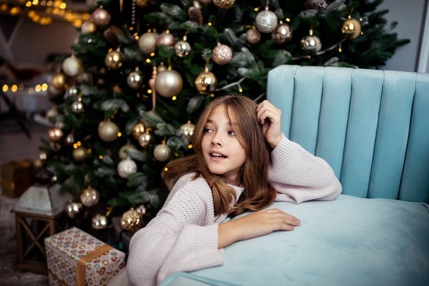 Carina ragazza adolescente in una stanza con un albero di Natale decorato. Le vacanze invernali. Foto di alta qualità - Foto, immagini