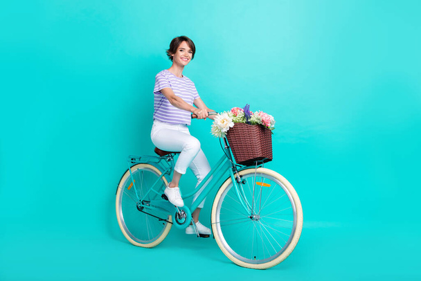 Full length photo of funny cute girl dressed purple t-shirt riding bicycle isolated teal color background. - Zdjęcie, obraz