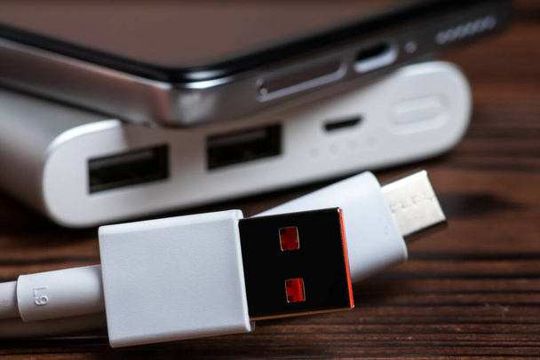 Hordozható tápegység USB-kábellel és okostelefonnal mobil eszközök töltéséhez. - Fotó, kép