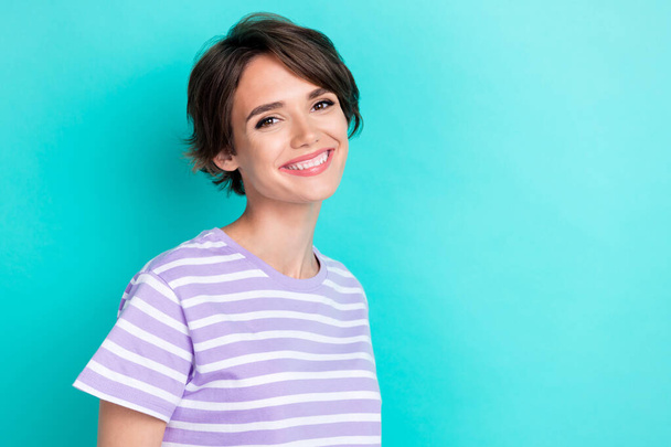 Photo of pretty shiny girl dressed purple t-shirt smiling empty space isolated teal color background. - Fotografie, Obrázek