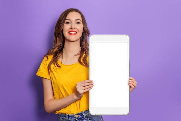 Mobile App. Caucasian young woman smiling and holding big smartphone with blank white screen, copy space for Design. Mockup - Φωτογραφία, εικόνα