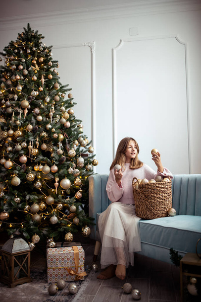 Söpö teini tyttö huoneessa koristeltu joulukuusi. Talvilomat. Laadukas kuva - Valokuva, kuva