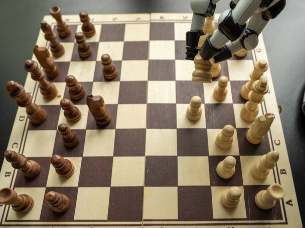A man plays chess with a robot. The concept of man versus robot. - Foto, afbeelding