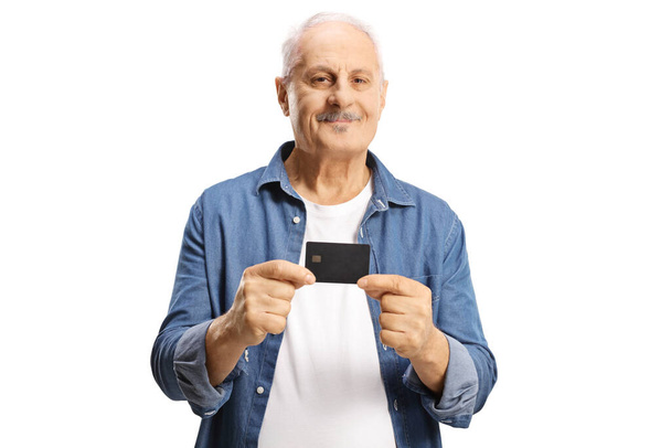 Mature man holding a credit card isolated on white background - Foto, afbeelding