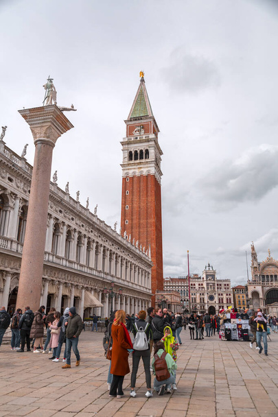 Venice, Italy - April 2, 2022: Historical landmarks and people walking at St. Mark's Square, or Piazza San Marco in Venice, Veneto, Italy. - Фото, изображение