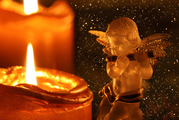 Ángel de Navidad haciendo música frente a la corona de Adviento - Foto, imagen