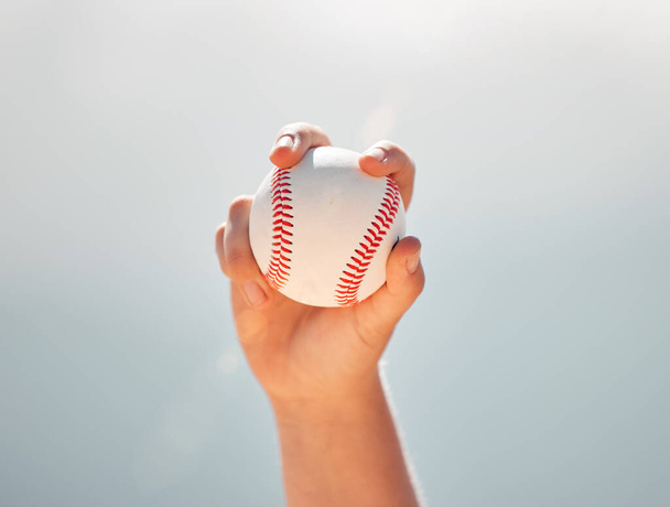 Baseball, mani di atleta e sport con la palla, mostrando la presa della brocca contro un cielo blu chiaro. Esercizio, gioco e softball con un giocatore professionista pronto a lanciare o lanciare durante una partita all'aperto. - Foto, immagini