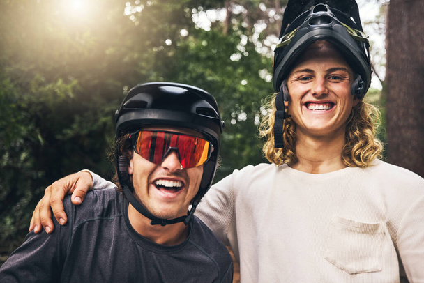 Friends taking a selfie together after cycling through nature trail in the forest. Portrait of cyclist men from Sweden or Norway smiling wearing mountain biking helmets after bicycle ride in a park. - Photo, Image