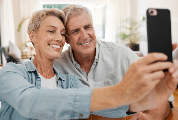 Idős pár szelfizik a telefont, mosolyognak szerelmes 5g és technológia a közösségi média a házasság a házban. Boldog, házas és mosolygós férfi és nő streaming, kommunikáció vagy videohívás. - Fotó, kép