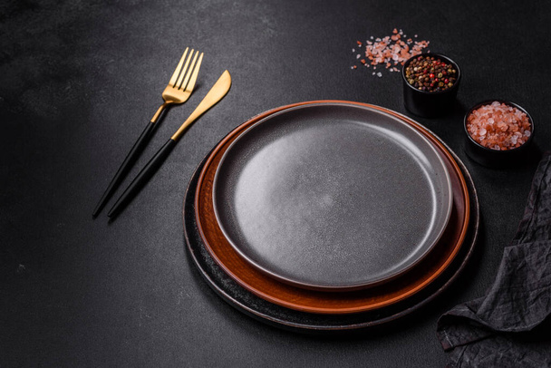Beton bir masada siyah çatal bıçak takımı. Yemek masası hazırlığı - Fotoğraf, Görsel