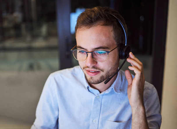 Call center, customer service and telemarketing with a man working in support with a headset in his office. Sales, consulting and contact us with a male consultant at work in crm communication. - Fotografie, Obrázek