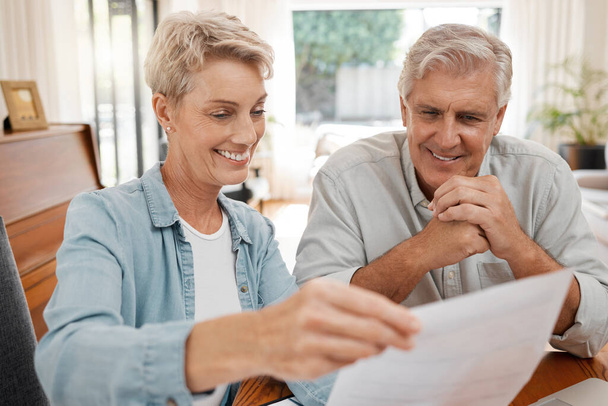 Happy couple, reading and paperwork or document for bill, mortgage or retirement plan or payout while sitting at home. Mature man and woman busy with tax compliance or finance form for pensioners. - Valokuva, kuva