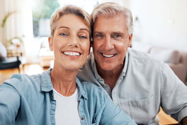 Senioren-Selfie-Porträt in der Home Lounge für Liebe, Pflege und einen entspannten Tag zusammen. Gesichter von lächelnden Männern, glücklichen Frauen und Rentnern, die Videotelefonie, hochwertige Zeit und enge Ehebeziehung genießen. - Foto, Bild