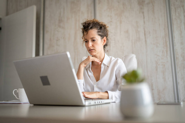 Jedna młoda kobieta kaukaska z powrotem do pracy w biurze pracuje nad laptopem przedsiębiorca nowoczesny biznes kobieta koncepcja - Zdjęcie, obraz