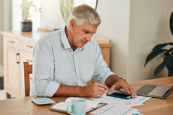 Man, elderly and phone for tax or budget banking with paper at home. Senior, laptop and paperwork with calculator on desk use web for planning, savings and financial compliance in South Africa. - 写真・画像