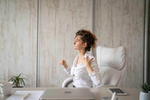 Jedna kobieta freelancer stretch w biurze w pracy siedzi w fotelu przy biurku za pomocą laptopa z bólem pleców cierpiących na ból szyi przepracowanie i wyczerpanie koncepcja kopiowanie przestrzeni - Zdjęcie, obraz