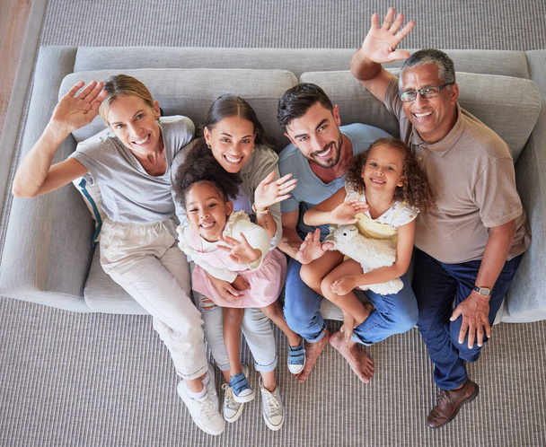 Hands, wave and big family top view on sofa or couch in living room home. Portrait of caring mom, dad and girls with grandparents together in house lounge spending time together, bonding and love - Fotó, kép
