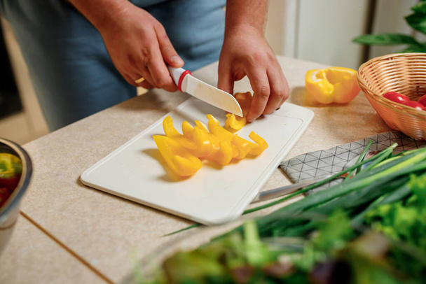 Detailní záběr muže připravujícího zeleninový veganský salát v kuchyni. Zdravé jídlo a dietní koncept životního stylu. Vařit doma - Fotografie, Obrázek