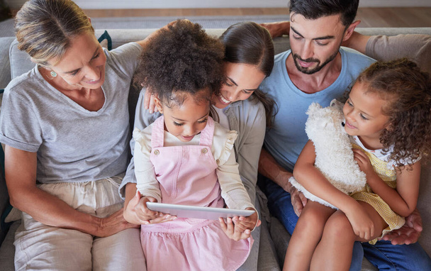 Nonni, genitori e bambini cheimparano con un tablet sul divano in casa di famiglia. Bambini su gadget digitale per l'apprendimento online, siti web per bambini e giochi educativi che mostrano l'educazione digitale della famiglia. - Foto, immagini