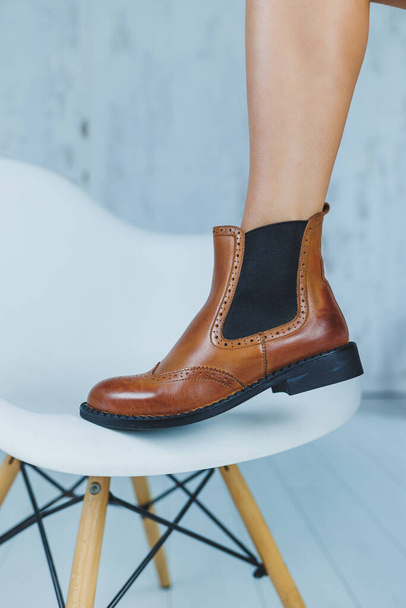 Крупный план женских ног в коричневых кожаных сапогах Chelsea. Новая осенняя коллекция женской кожаной обуви 2022 года - Фото, изображение