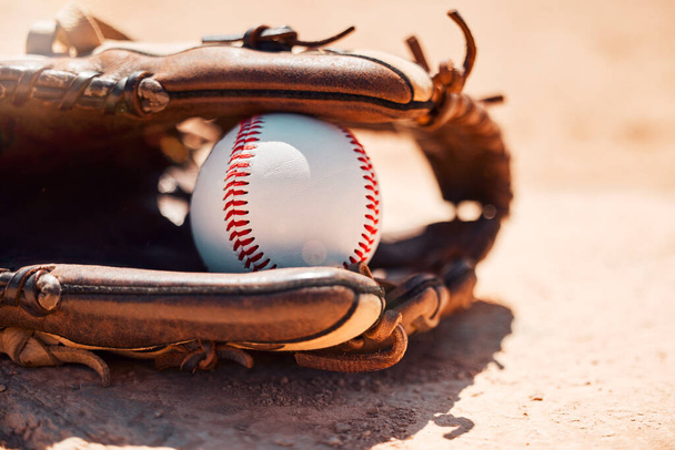 Baseball, sport and exercise with a ball and glove on a base plate on a pitch or field outdoor for a competitive game or match. Fitness, sports and skill with equipment on the ground for training. - Фото, изображение