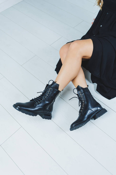 Fashionable leather boots with laces on a woman's leg, close-up, fashionable. New collection of leather autumn women's shoes - 写真・画像
