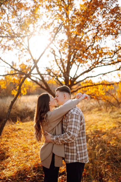 Happy couple in love newlyweds in casual clothes travel together, hike and walk in the autumn forest in nature. - Фото, изображение