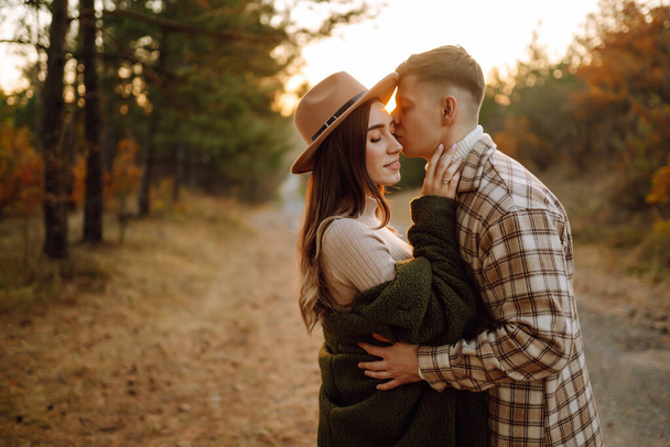 Happy couple in love newlyweds in casual clothes travel together, hike and walk in the autumn forest in nature. - Fotó, kép
