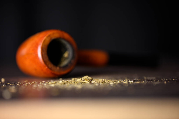 Old sailors smoking pipe with tobacco droppings on wooden table. High quality photo - Foto, afbeelding