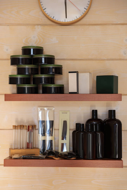 Shelves with professional hair cosmetics on wall in barbershop - Фото, изображение