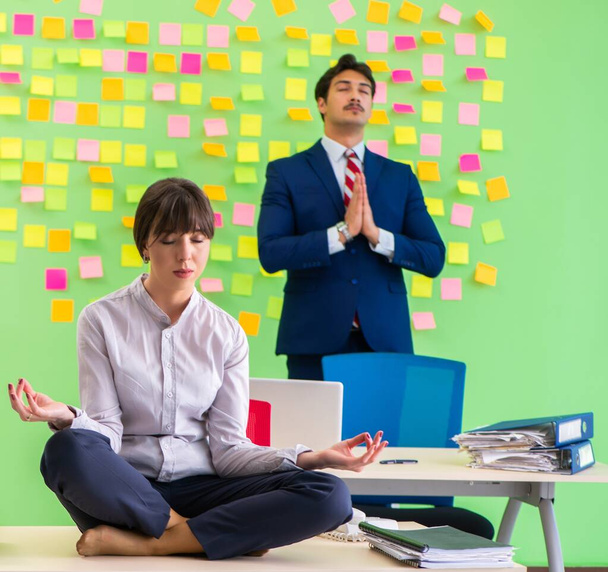 Man and woman in the office with many conflicting priorities in yoga concept - Photo, Image