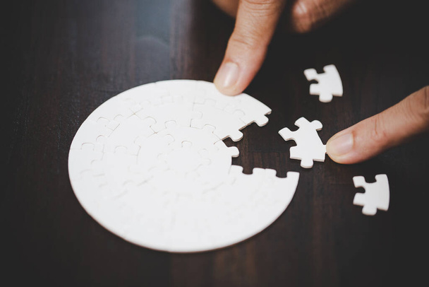 Business woman person hand with puzzle piece idea for strategy and solution. Closeup part of two white jigsaw connect together. Concept of join cooperation success teamwork-problem corporate team. - Photo, Image