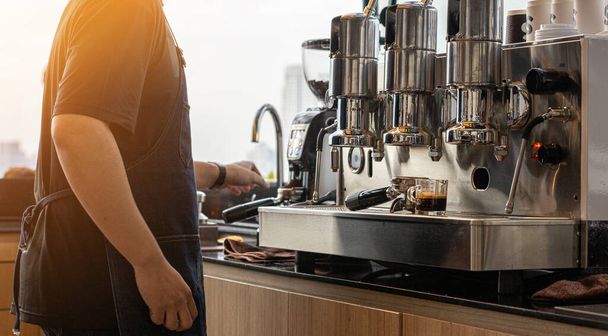 Barista maakt een warme verse koffie met machine voor de klant.  - Foto, afbeelding
